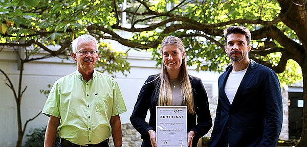 Präsentierten das Zertifikat des Energieaudits im Garten der PASS Zentrale in Aschaffenburg: (von links) Stefan Luckhaus (Head of Internal Audit, PASS) Selina Becker (Immobilienmanagement, PASS) und Jan Rienecker (Mitglied des Board of Executives, PASS)