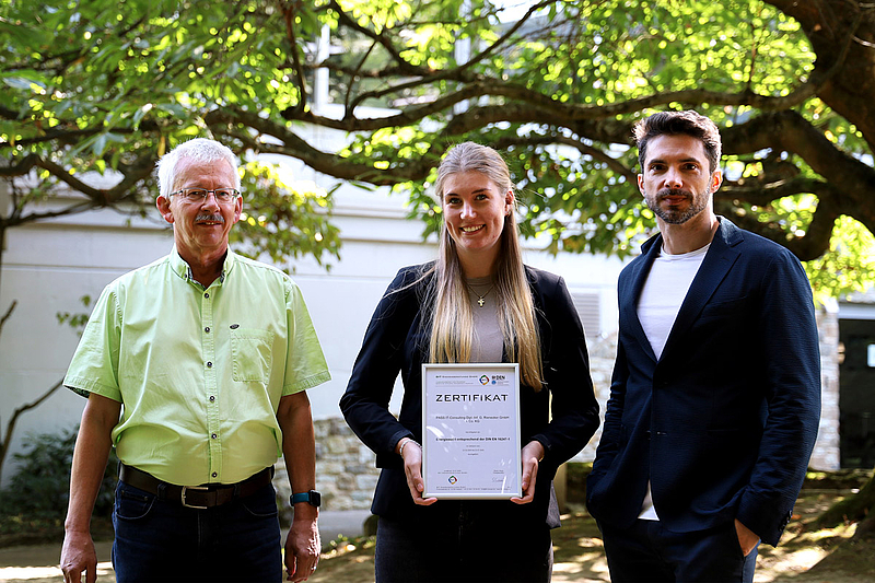 Präsentierten das Zertifikat des Energieaudits im Garten der PASS Zentrale in Aschaffenburg: (von links) Stefan Luckhaus (Head of Internal Audit, PASS) Selina Becker (Immobilienmanagement, PASS) und Jan Rienecker (Mitglied des Board of Executives, PASS)