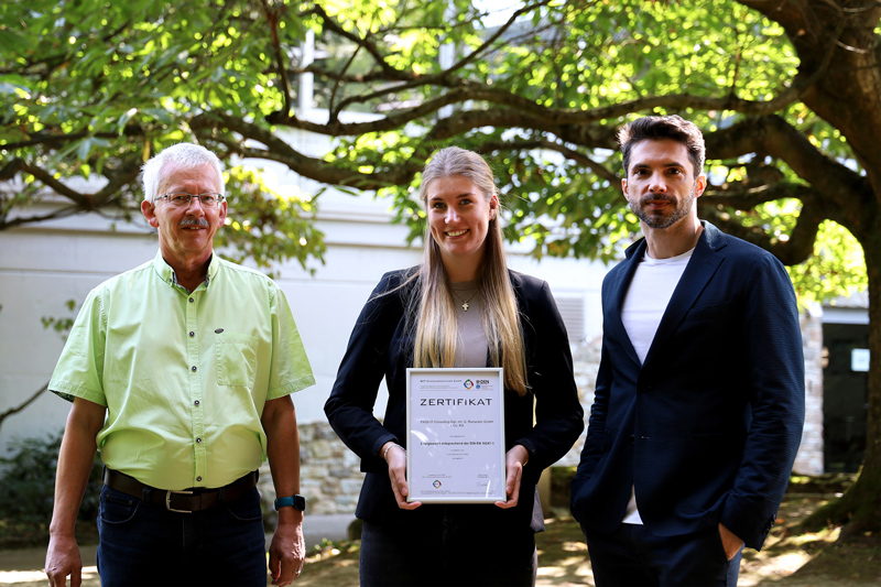 Im Bild (von links): Stefan Luckhaus (Head of Internal Audit, PASS) Selina Becker (Immobilienmanagement, PASS) und Jan Rienecker (Mitglied des Board of Executives, PASS) präsentieren das Zertifikat des Energieaudits im Garten der PASS Zentrale in Aschaffenburg.